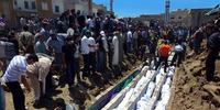 Houla residents bury the bodies of dozens of people killed in the Syrian military's assault on the town.