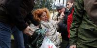クリミア自警団と名乗る男性100人が、約40名の女性が行っていた平和的な抗議活動を無理やりやめさせた。（3月5日、クリミア自治共和国の首都シンフェロポリにて）(C) VOLODYMYR PETROV/AFP/Getty Images