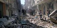 Syrians inspect the rubble of destroyed buildings following a Syrian government airstrike in Aleppo, March 2014.(C) AP Photo/Aleppo Media Center AMC