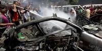 Fire fighters extinguish a vehicle targeted in an Israeli airstrike on Gaza City on 8 July, 2014.(C) MOHAMMED ABED/AFP/Getty Images