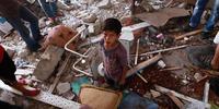 Palestinians inspect a damaged classroom of the UN school in Jabaliya, northern Gaza Strip.(C) EPA/MOHAMMED SABER