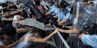 Police clash with student pro-democracy protesters in Hong Kong. Students use umbrellas as shields from pepper spray.(C) Lam Yik Fei/Getty Images