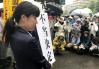 東京高裁前で「不当決定」の垂れ幕を掲げる弁護士