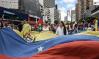 Protesters seen holding a huge Venezuela flag © Roman Camacho/SOPA/LightRocket/Getty