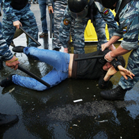 警察棒で殴られるデモに参加した一般市民。2012年5月、モスクワ