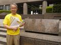 署名を手にするアムネスティ日本事務局長の若林。検察庁前にて。