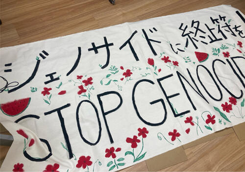 「ジェノサイドに終止符を！STOP GENOCIDE」というメッセージを込めた横断幕