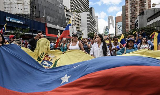 Protesters seen holding a huge Venezuela flag © Roman Camacho/SOPA/LightRocket/Getty 