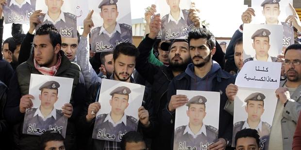 Activists carry posters with a portrait of the Jordanian pilot Maaz al-Kassasbeh. © KHALIL MAZRAAWI/AFP/Getty Images