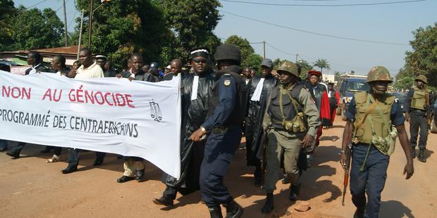 中央アフリカ共和国の首都バンギで警察の護衛を受けながら、暴力反対のデモをする人たち(C) PACOME PABANDJI/AFP/Getty Images