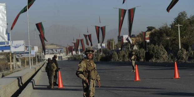 Afghan policemen stand guard near the premises where the forthcoming Loya Jirga will be held in Kabul.(C) MASSOUD HOSSAINI/AFP/Getty Images