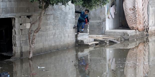 Children play in streets flooded with raw sewage in al-Zaytoun, south of Gaza City, after the shutdown.(C)MAHMUD HAMS/AFP/Getty Images