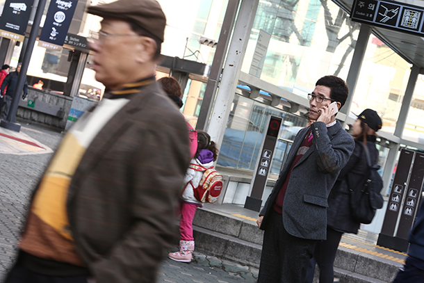 Choi Hyun-joon, a North Korean living in Seoul, Korea, using a phone outside a downtown subway station. He was unable to get in touch with his daughter, Choi Ji-woo, when he fled North Korea, due to the country's restrictions on international phone calls.